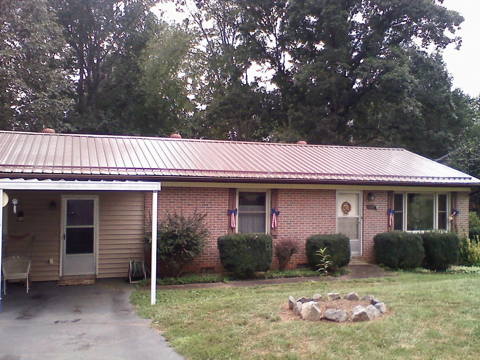 Bronze metal roof and carport on a brick ranch home — Roof Repair work by our crew in Stanford